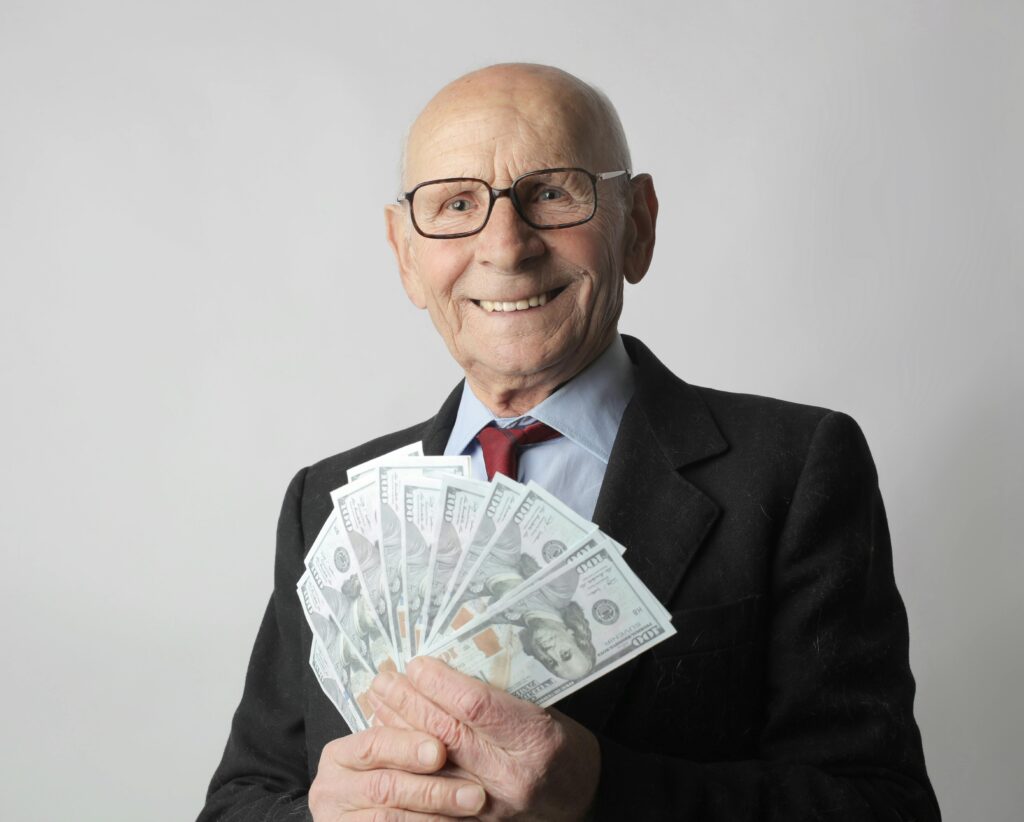 senior man holding $100 bills
